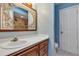 Bathroom vanity featuring floral designed mirror, wood cabinets, sink and toilet at 380 Violet Dell Dr, Casselberry, FL 32707