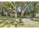 A backyard view of the house featuring a sunroom, patio, and mature trees for shade at 380 Violet Dell Dr, Casselberry, FL 32707