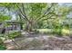 A view of the backyard with an outdoor patio, sunroom, beautiful garden and mature trees at 380 Violet Dell Dr, Casselberry, FL 32707