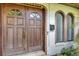 Close up of the wooden double front doors, brick trim, and a window box at 380 Violet Dell Dr, Casselberry, FL 32707