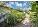 View of a sidewalk leading to the front of the house through lush greenery at 380 Violet Dell Dr, Casselberry, FL 32707