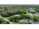 Lush community aerial view of various properties nestled amongst mature trees and landscaping with a pond in view at 4018 August Ct, Casselberry, FL 32707