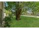 Well-maintained front yard with lush green grass and mature tree offering shade at 4018 August Ct, Casselberry, FL 32707
