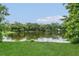 Scenic view of a serene pond surrounded by lush greenery and trees at 4018 August Ct, Casselberry, FL 32707