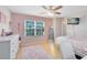 Bedroom features hard wood floors, a ceiling fan, and large window at 4478 Yachtmans Ct, Orlando, FL 32812