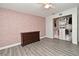 Bedroom featuring gray wood floors, rose-patterned accent wall, and closet with shelving at 448 Stonewood Ln, Maitland, FL 32751