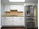 Cozy kitchen featuring stainless steel refrigerator, white cabinets and patterned backsplash at 448 Stonewood Ln, Maitland, FL 32751