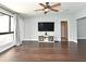 Open living room with ceiling fan, large screen tv, and sleek dark wood floors at 448 Stonewood Ln, Maitland, FL 32751
