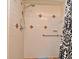 Close-up of a tiled shower with grab bar and patterned shower curtain at 448 Stonewood Ln, Maitland, FL 32751
