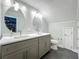 Bathroom featuring dual sinks, modern lighting, and a toilet with a nearby doorway at 4584 Virginia Dr, Orlando, FL 32814