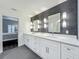 Bathroom with dual sinks, textured wall, and white cabinetry at 4584 Virginia Dr, Orlando, FL 32814