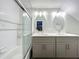 Bright bathroom with dual sinks, modern lighting fixtures, and a glass-enclosed shower at 4584 Virginia Dr, Orlando, FL 32814