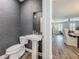 Modern powder room with pedestal sink, dark wallpaper, and view into the adjacent rooms at 4584 Virginia Dr, Orlando, FL 32814