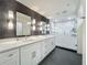 Modern bathroom with a double vanity, stylish mirrors, and a spacious walk-in shower with white subway tile at 4584 Virginia Dr, Orlando, FL 32814