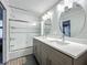Bathroom with double sinks, modern lights, and a glass-enclosed shower/tub combination at 4584 Virginia Dr, Orlando, FL 32814