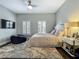Comfortable bedroom with plantation shutters and a ceiling fan, centered around a cozy bed at 4584 Virginia Dr, Orlando, FL 32814