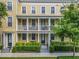 Charming townhome showcasing double balconies supported by stately columns, set amidst manicured green landscaping at 4584 Virginia Dr, Orlando, FL 32814
