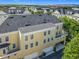 A sunny view of a bright yellow townhome with a well-maintained roof, multiple windows, and a spacious garage at 4584 Virginia Dr, Orlando, FL 32814