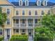 Attractive three-story townhome featuring a second-story balcony and manicured landscaping at 4584 Virginia Dr, Orlando, FL 32814