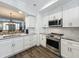 Well-equipped kitchen with stainless steel appliances, white cabinetry, subway tile backsplash, and marble countertops at 4584 Virginia Dr, Orlando, FL 32814