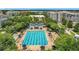 Aerial view of a community pool with lap lanes, lounge chairs, and a pool house, surrounded by mature trees at 4584 Virginia Dr, Orlando, FL 32814