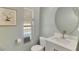 Bathroom featuring a round mirror, a white vanity sink with silver faucet, and a neutral colored wall paint at 486 Shirley Dr, Apopka, FL 32712