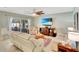 Spacious living room with ceiling fan and tile flooring, plush leather couches, and sliders to the pool at 486 Shirley Dr, Apopka, FL 32712