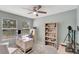 Well-lit home office with a ceiling fan, light-colored desk and shelving, and a gray carpet at 486 Shirley Dr, Apopka, FL 32712