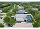 Aerial view of a home with a screened pool, lush green lawn and mature trees at 486 Shirley Dr, Apopka, FL 32712