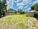 Spacious backyard featuring a large grassy area, mature trees, shed, and the rear exterior of the single story home at 531 Wigman Dr, Eatonville, FL 32751