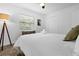 Bright bedroom featuring a comfortable bed with a modern lamp and a view from the window at 531 Wigman Dr, Eatonville, FL 32751