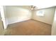 Neutral bedroom with a ceiling fan, window, and carpeted floor at 5472 E Grant St, Orlando, FL 32812
