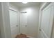 Hallway featuring hardwood floors and three doors at 5472 E Grant St, Orlando, FL 32812
