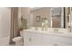 Well-lit bathroom with double sinks, modern fixtures, and decorative accents over the toilet at 5626 Portico Pl, Kissimmee, FL 34758