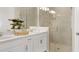 Modern bathroom with double vanity, white cabinets, quartz countertops, and a glass-enclosed shower at 5626 Portico Pl, Kissimmee, FL 34758