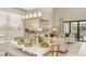 Elegant dining area with natural light, a modern chandelier, and access to the outdoor living space at 5626 Portico Pl, Kissimmee, FL 34758