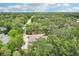 Expansive aerial shot showcasing the home nestled among mature trees and the surrounding neighborhood at 5836 Spruce Creek Woods Dr, Port Orange, FL 32127