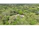 High-angle aerial view of the home situated within a dense, wooded landscape at 5836 Spruce Creek Woods Dr, Port Orange, FL 32127