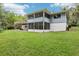 Expansive backyard with a deck, screened-in porch and lush lawn, perfect for outdoor gatherings at 5836 Spruce Creek Woods Dr, Port Orange, FL 32127