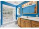 Bright bathroom with a glass block shower, vanity, and tile floors at 5836 Spruce Creek Woods Dr, Port Orange, FL 32127
