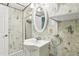 Charming bathroom features a walk-in shower, oval mirror, and vintage-inspired wallpaper at 5836 Spruce Creek Woods Dr, Port Orange, FL 32127