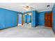 Spacious carpeted bedroom with blue walls, ceiling fan, and mirrored closet at 5836 Spruce Creek Woods Dr, Port Orange, FL 32127