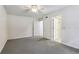 Bedroom features neutral carpet, multiple doors, and a ceiling fan at 5836 Spruce Creek Woods Dr, Port Orange, FL 32127