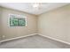 Comfortable bedroom featuring a ceiling fan and neutral carpeting, plus a window with outside views at 5836 Spruce Creek Woods Dr, Port Orange, FL 32127