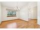 Bright dining room featuring hardwood floors, a chandelier, and a large window with backyard views at 5836 Spruce Creek Woods Dr, Port Orange, FL 32127