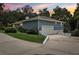 Charming exterior of the home with a two-car garage and well-manicured lawn at 5836 Spruce Creek Woods Dr, Port Orange, FL 32127