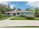 Charming single-story home with a well-manicured lawn, lush landscaping, and a welcoming entrance at 5836 Spruce Creek Woods Dr, Port Orange, FL 32127