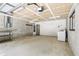 Spacious garage featuring exposed ceiling, painted walls, and natural light from window at 5836 Spruce Creek Woods Dr, Port Orange, FL 32127