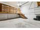 Large garage area with a loft space, featuring wooden stairs, built-in shelves, and additional storage at 5836 Spruce Creek Woods Dr, Port Orange, FL 32127