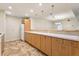 Bright kitchen showcasing a long counter with wood cabinets, tiled backsplash and neutral tile flooring at 5836 Spruce Creek Woods Dr, Port Orange, FL 32127